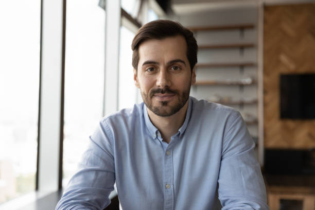 Head shot of confident friendly business professional looking at camera during online virtual conference, video call. Screen view portrait of millennial business man, employee, teacher giving webinar
